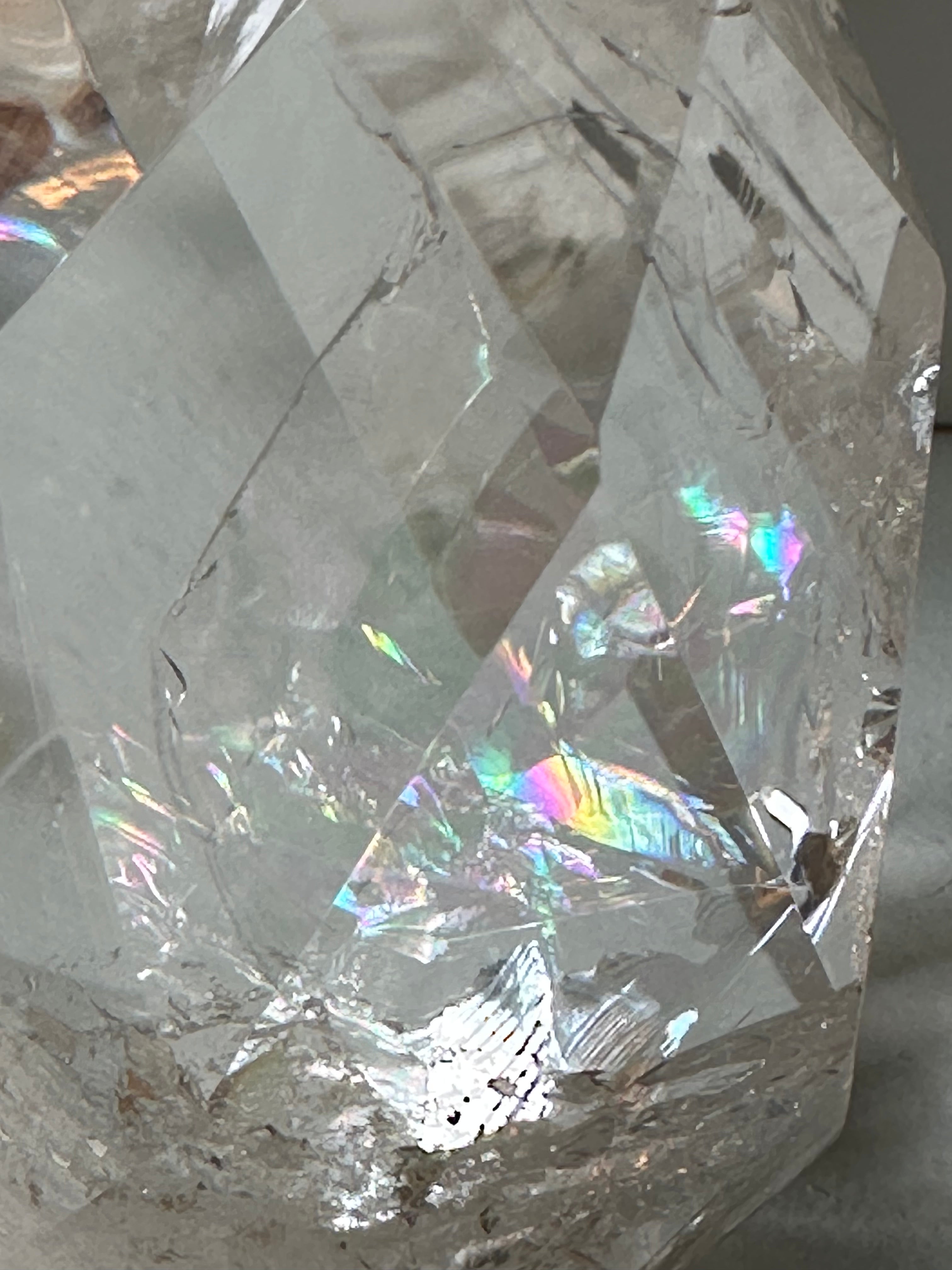 Close-up of a quartz crystal with reflective surfaces and rainbows